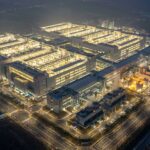 夜間に輝く最新メモリ半導体工場の空撮イメージ