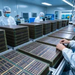 中国の半導体工場でDRAMウエハーの生産・検査が行われている様子。出荷待ちのメモリモジュールが積まれている構図。